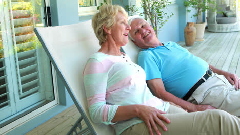 senior couple sitting on deck chairs