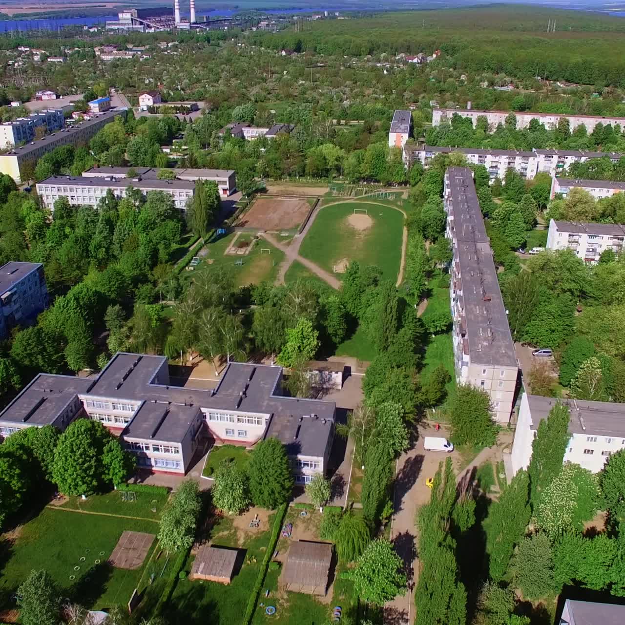 Sunny city drowning in the greenery. Drone footage of Ukrainian city on fantastic sunny day. Aerial perspective