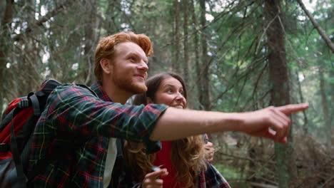 redhead man showing woman wild animal in woods