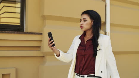 Serious-business-woman-having-video-call-outside