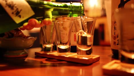 pouring sake into glasses in sequence