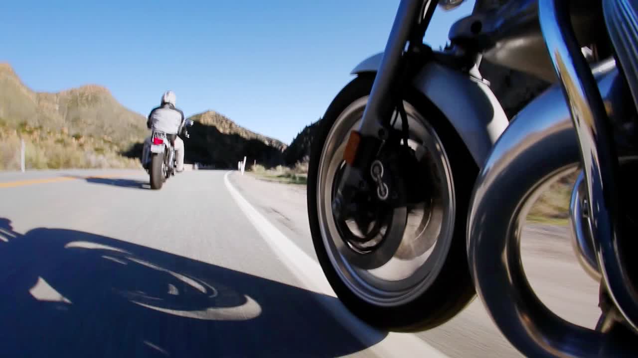 dos motociclistas toman la carretera abierta en el campo