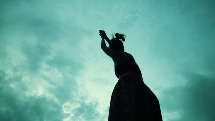 Woman in Yoga Pose Against a Dramatic Sky