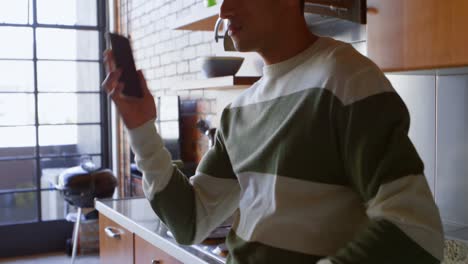 Man-talking-on-mobile-phone-in-kitchen-4k