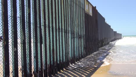 waves roll into the beach at the us mexico border fence in the pacific ocean between san diego and tijuana 1