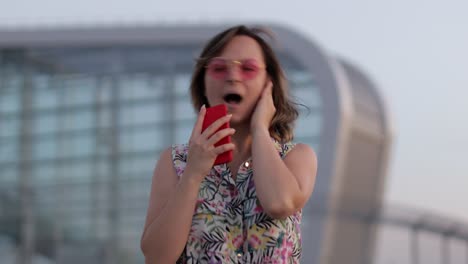 turista mujer feliz con gafas de sol rosas bailando y escuchando música en auriculares. moviéndose en baile