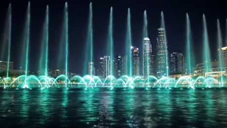 mesmerizing nighttime water fountain show featuring dynamic light displays and colorful water jets against a stunning urban skyline