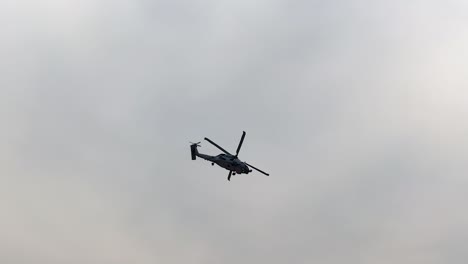 sikorsky seahawk performs aerial maneuvers against cloudy skies at avalon airshow, geelong, australia. spectators watch the dynamic display