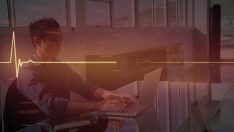 animación de un monitor cardíaco contra un hombre de negocios asiático que usa una computadora portátil en la oficina