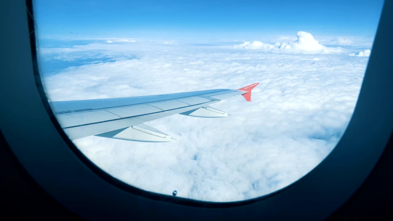 비행기의 창문에서 날개와 구름을 볼 수 있습니다.