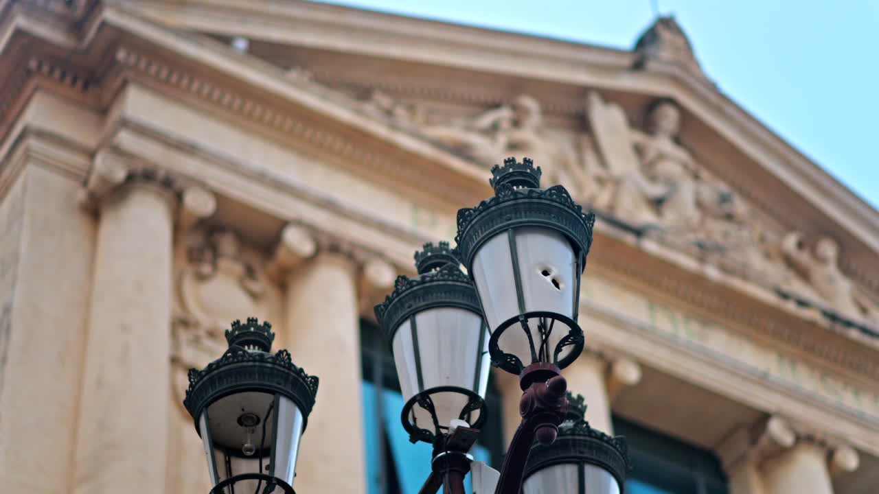 Close up of a street lamp with a blurred view of the Nice courthouse on the background
