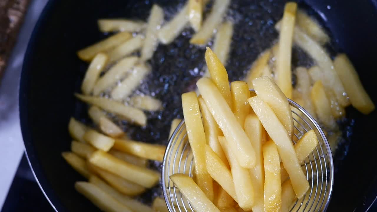 Close-up of french fries being fried in oil