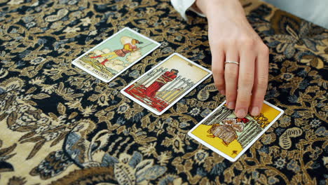 Eine-Frau-Liest-Eine-Tarot-Lesung-Mit-Der-Seite-Der-Schwerter,-Der-Acht-Der-Schwerter-Und-Der-Sechs-Der-Pokale