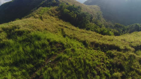 Toma-Aérea-En-Cámara-Lenta-De-Una-Mujer-Caminando-En-Una-Montaña-Con-Un-Mar-De-Nubes