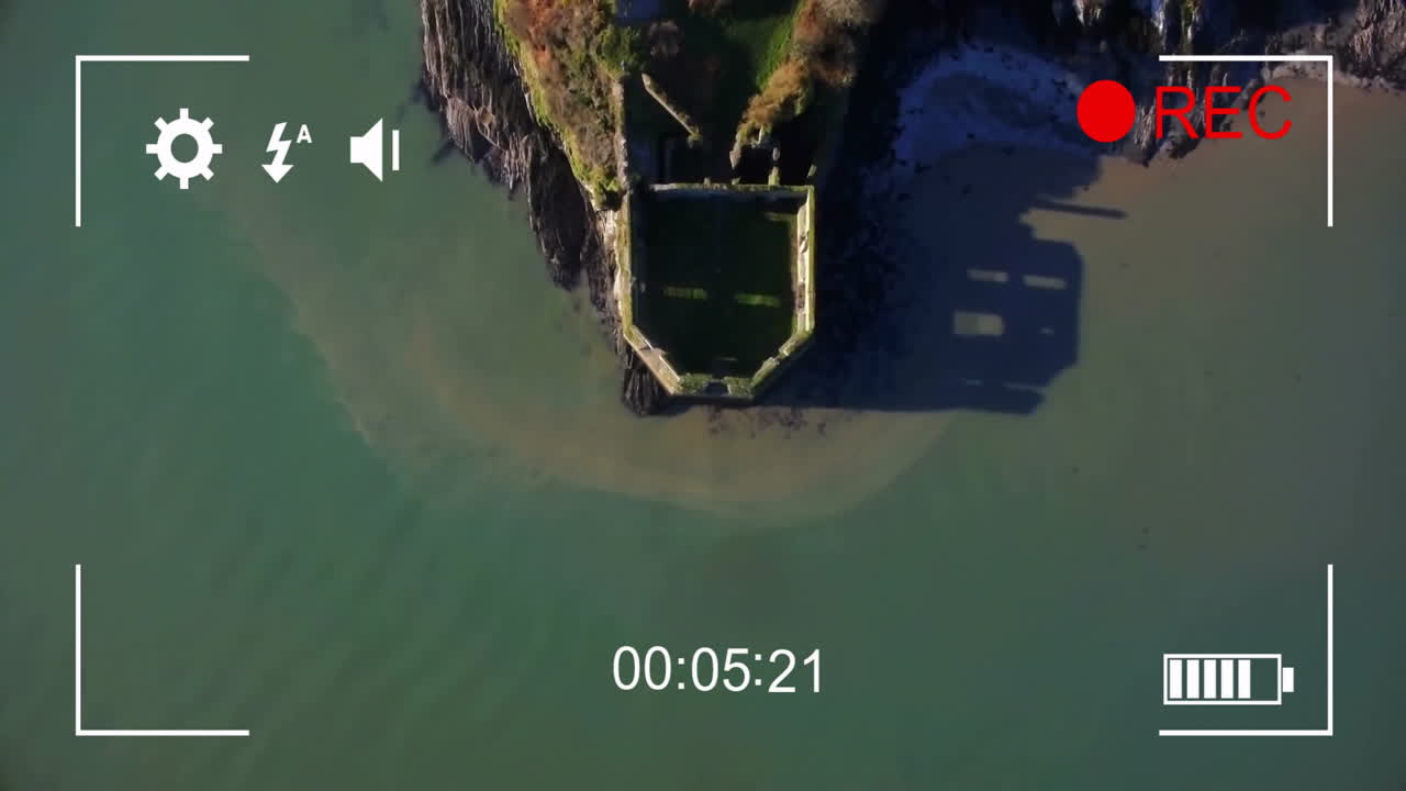 Aerial view of coastal ruins with video recording animation overlay