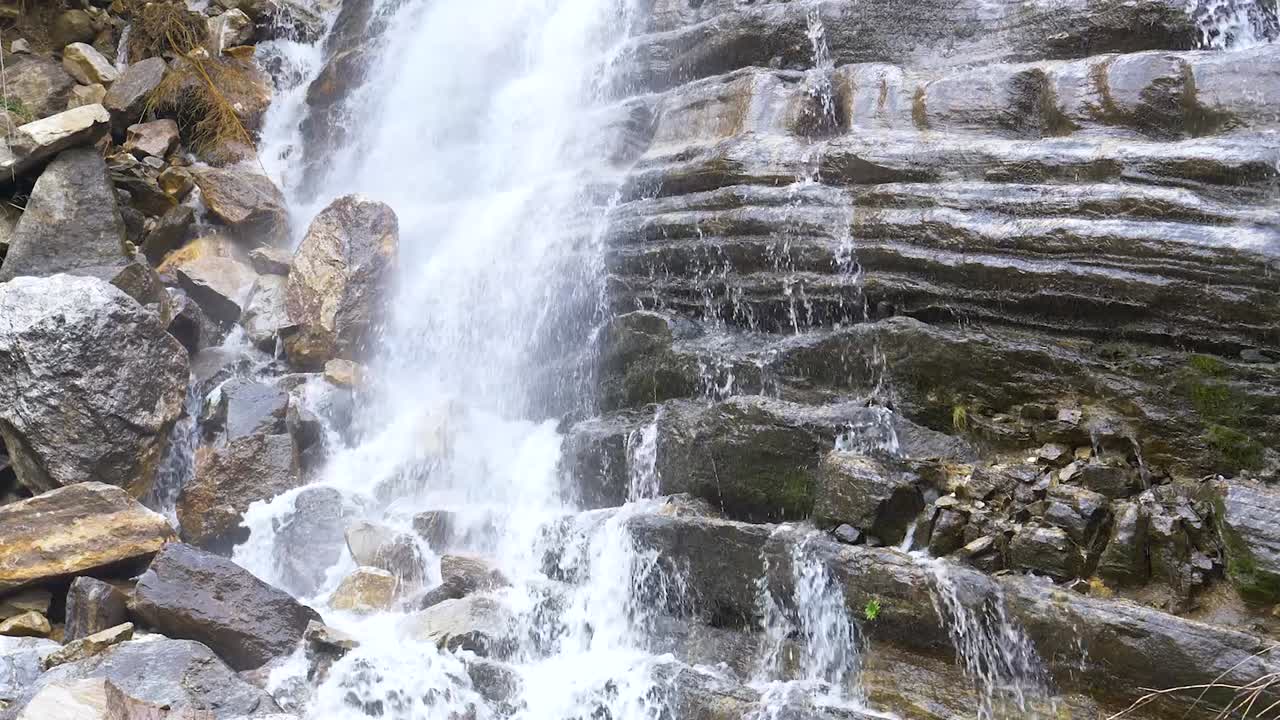 el agua brilla y brilla en cascada por las rocas dentadas debajo de la cascada