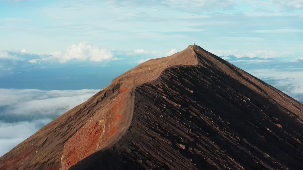 Drone Rising Above Golden Mountain Ridge at Sunrise. Cloudy Valley in the Background. 4k Footage.