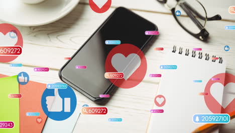 animation of social media like and love icons over smartphone on desk background