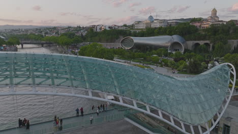 establishing shot of tourists on the peace bridge in tbilisi, georgia