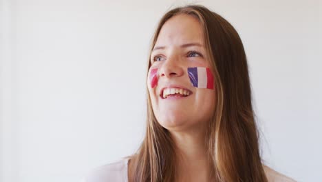 imagen de una mujer caucásica feliz con la bandera de francia aplaudiendo