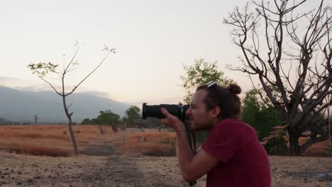 Young-Caucasian-man-taking-a-photo-in-the-Tianyar-Savana-with-negative-space-on-the-frame