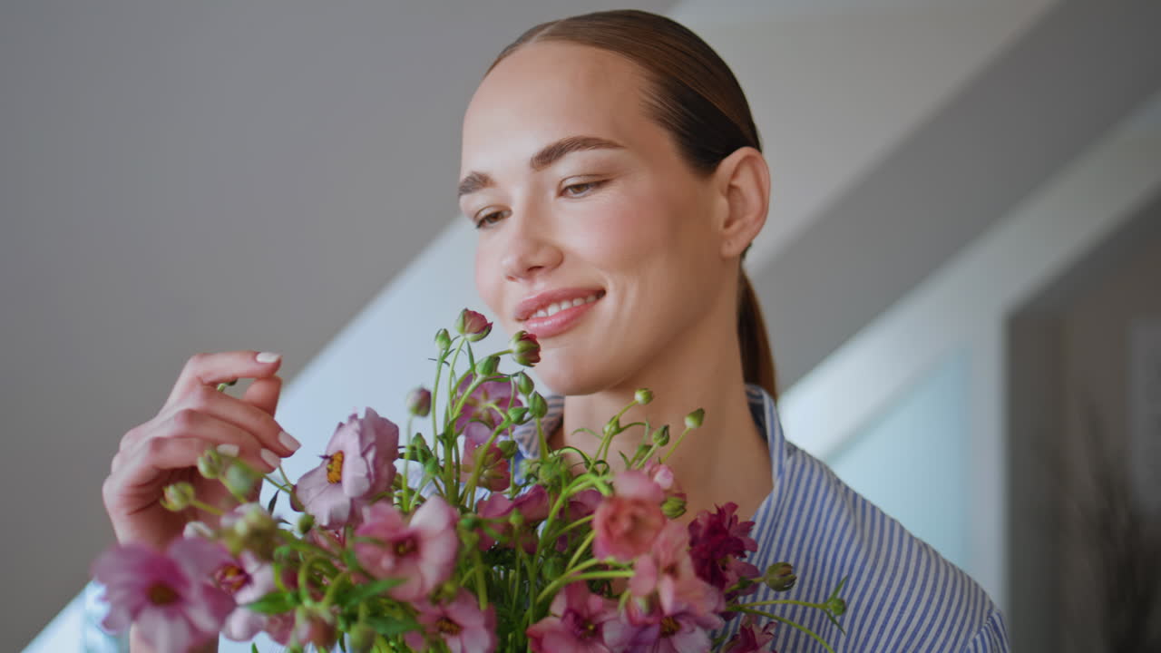Sensual girl carrying bloom looking camera at white ceiling apartment portrait