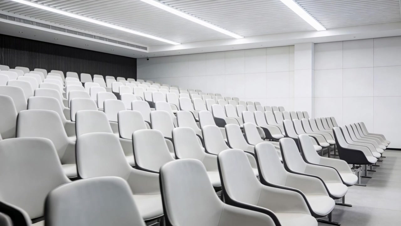 Panning camera revealing empty chairs in lecture auditorium, showing seating layout for lectures