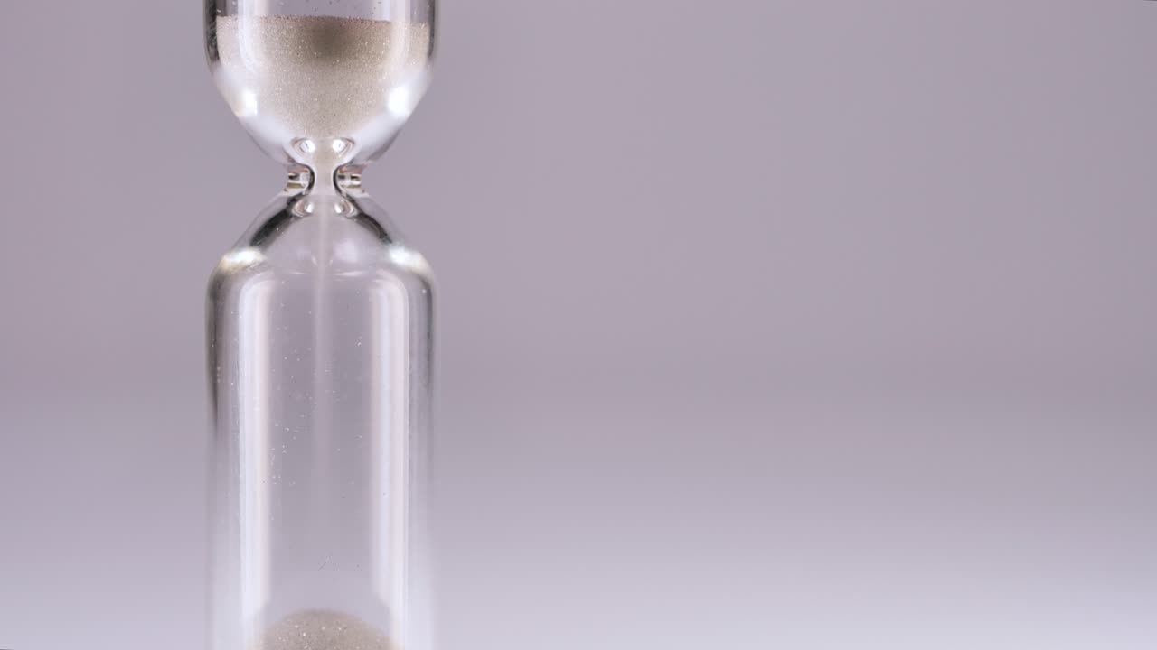 White sand running through bulbs of an hourglass