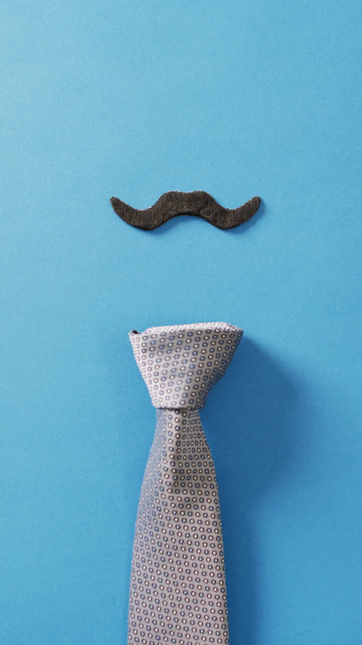 video vertical de bigote falso negro y corbata de patrón gris en fondo azul con espacio de copia
