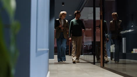 colleagues walking and talking in a modern office corridor