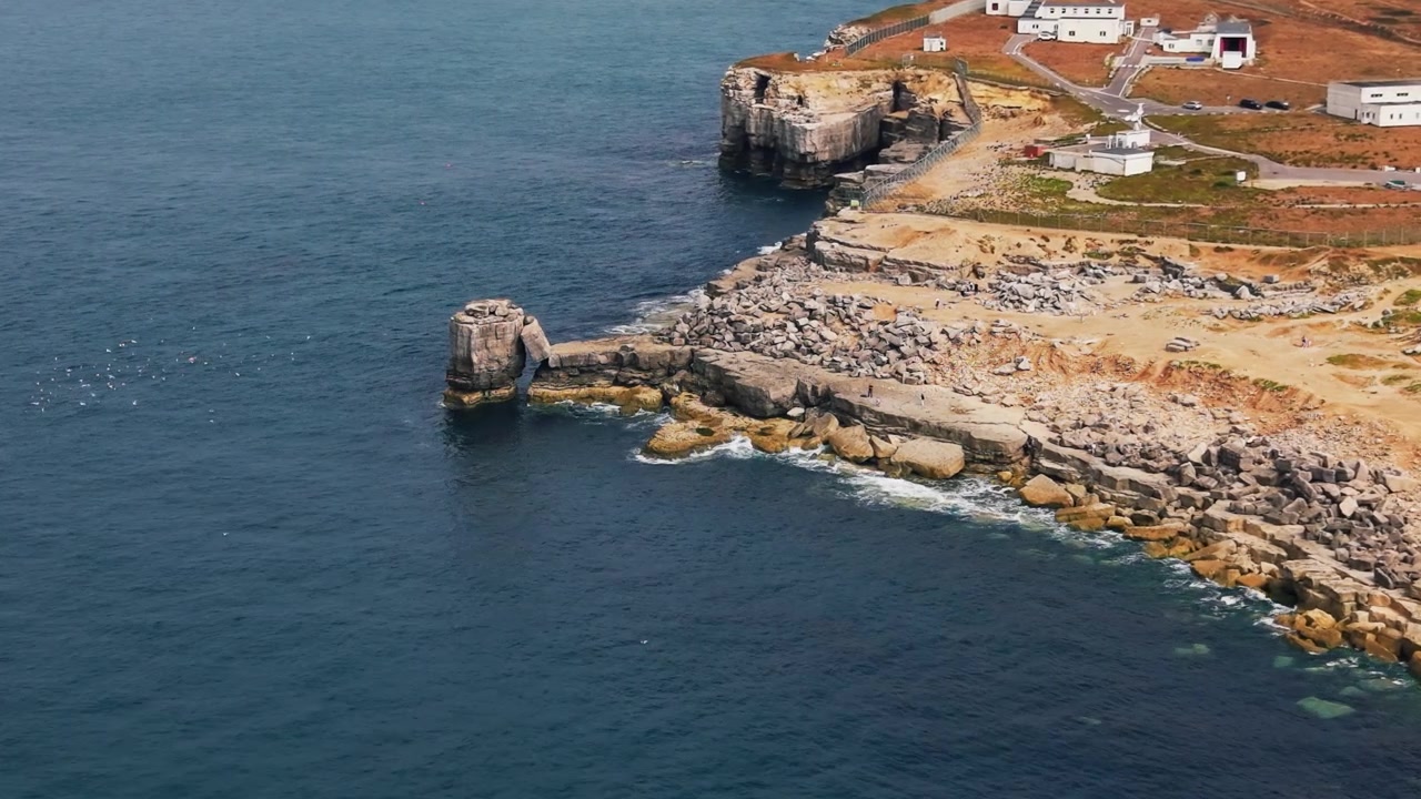 Vista drone di Pulpit Rock che si erge accanto a aspre sporgenze calcaree e un'ex cava sulla costa dell'Isola di Portland