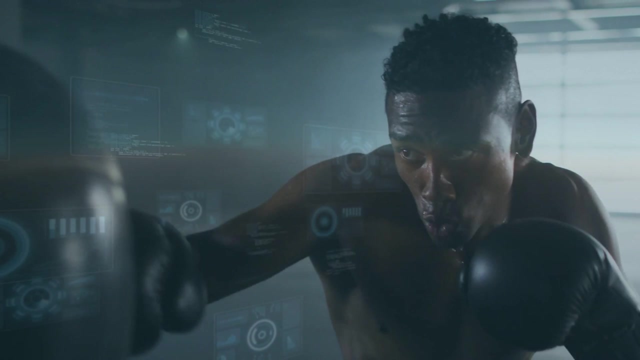 Boxeador sem camisa em posição de guarda, com luvas pretas, dando socos no saco na academia para feedback do HUD.