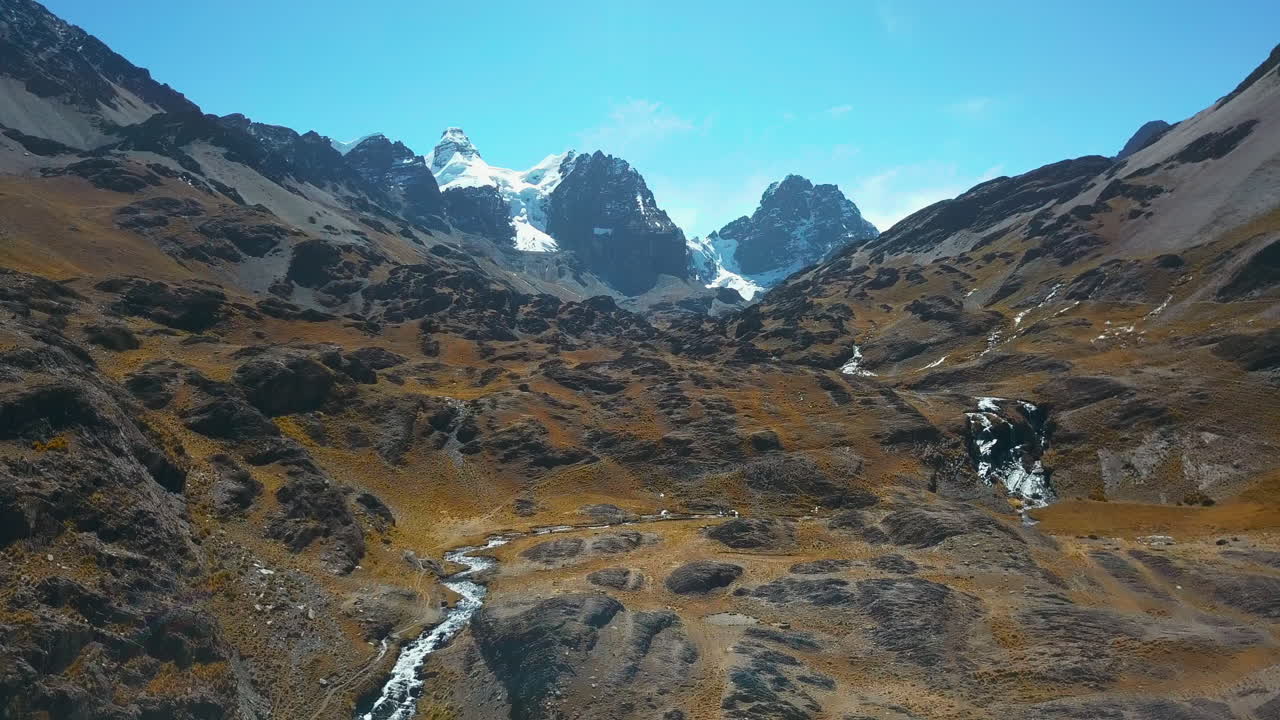 Stunning aerial drone view flying through a valley in the epic mountain landscape of the Andes.