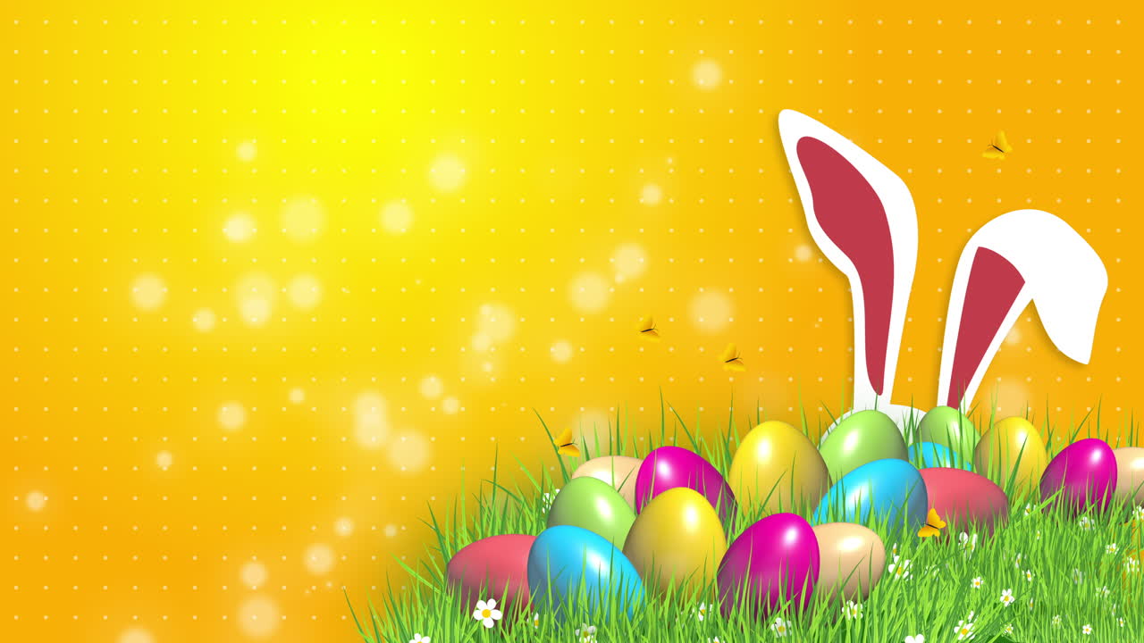 Easter colored eggs on green grass and rabbit ears. Abstract yellow background with blurred particles. Looped video.