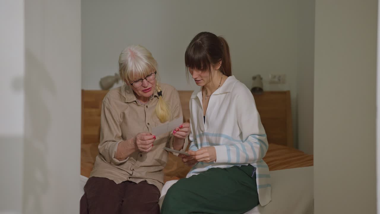 Grandmother and Granddaughter Sharing Old Photos