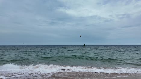 A-beautiful-day-on-the-beach-with-people-kiteboarding-in-the-ocean