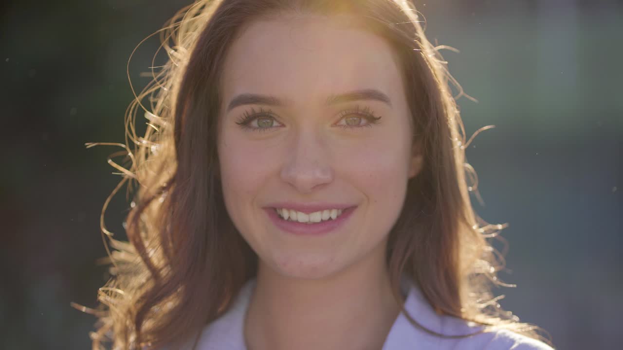 primer plano de una mujer bonita afuera mirando a la cámara, riendo