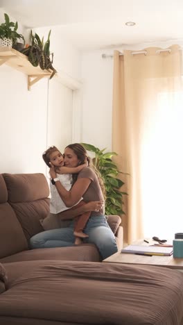 smiling mother and daughter caressing dog on sofa at home
