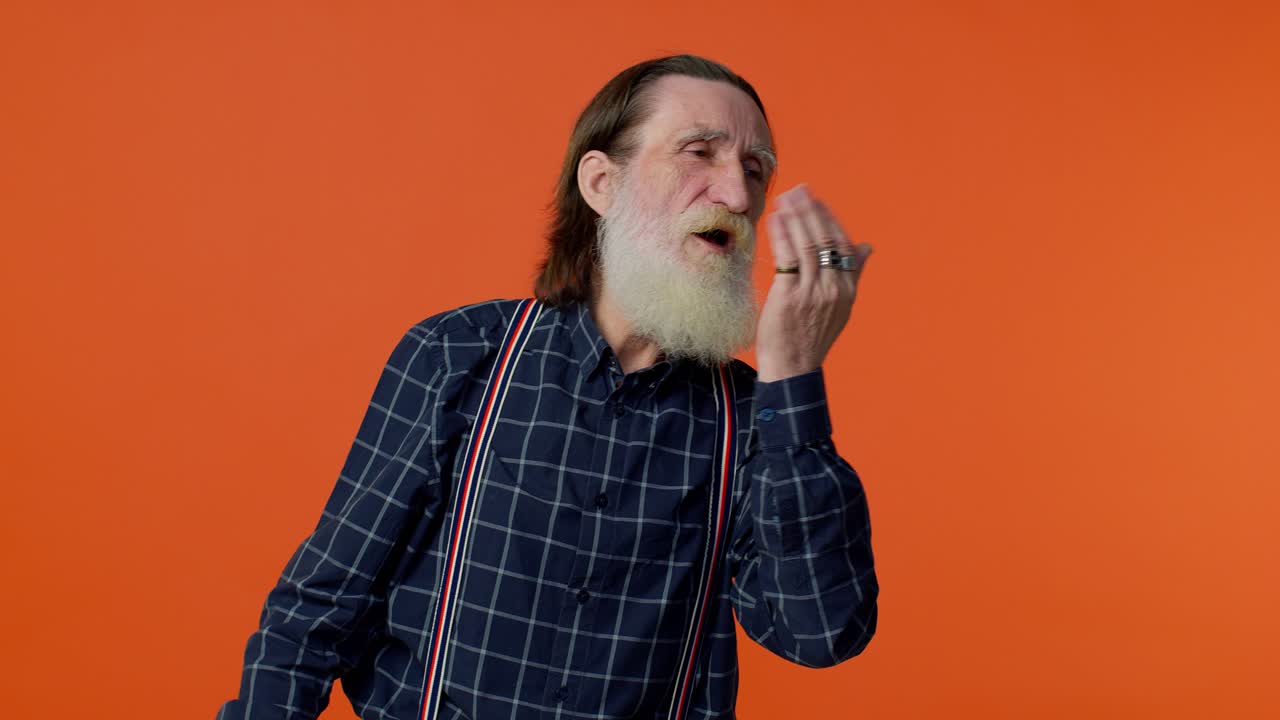 sonriente romántico anciano enviando muchos besos al aire mirando a la cámara y sonriendo, extrañándote