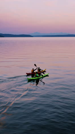 kayaking on a calm lake at sunset/sunrise with distant mountains