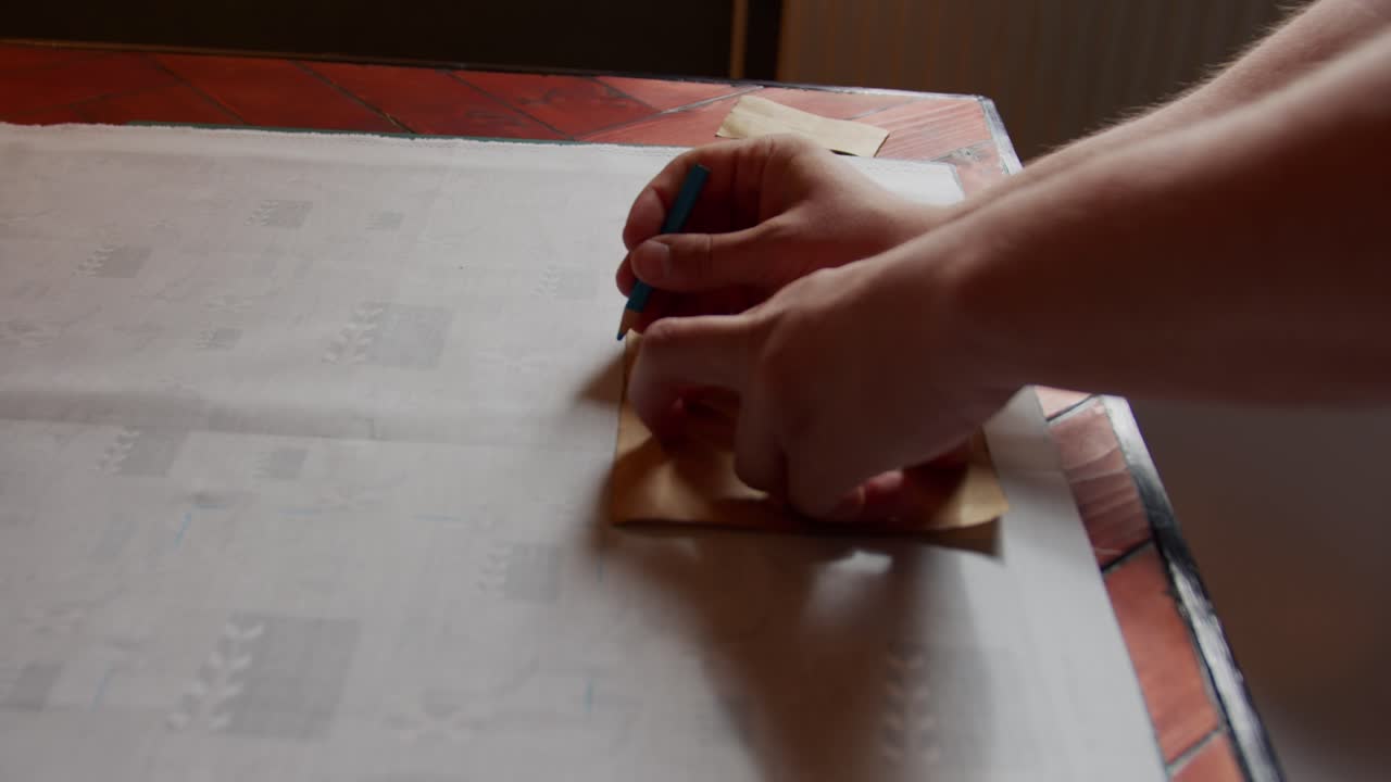 Marking out the pattern onto fabric. Slow motion. Natural light.