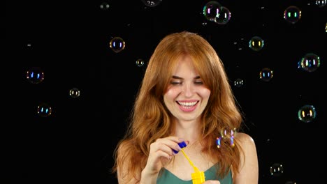 girl lets the soap bubbles black background girl lets multicolored soap bubbles and sincere smiles black background