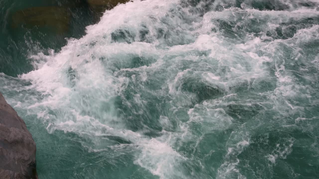 프랑스 시골에 있는 바위로 가득 찬 강 아래로 성난 맑고 푸른 물 가까이