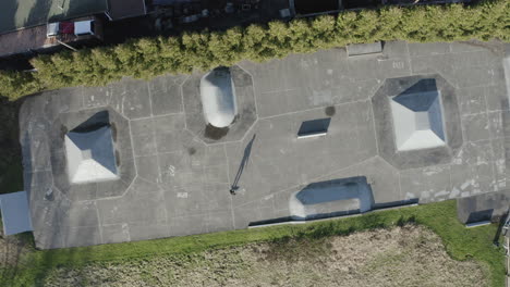 ascending aerial view of a skater practicing in an urban skatepark