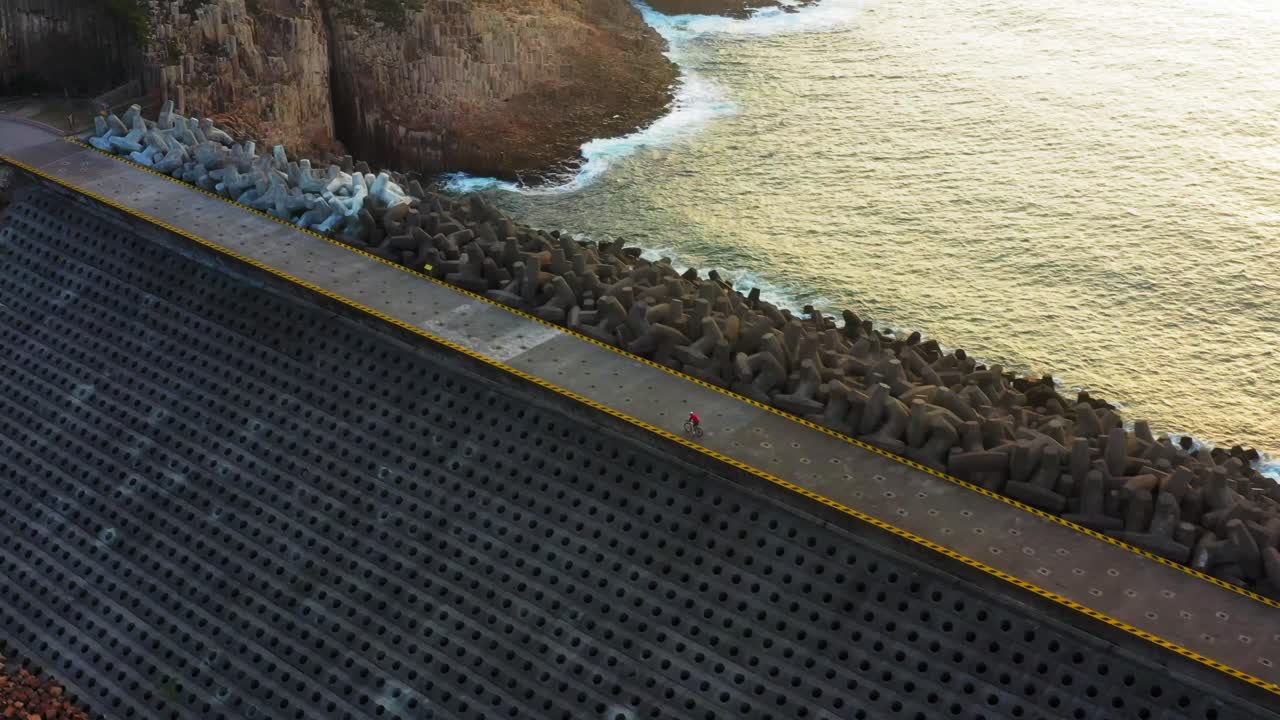 ciclista montando en el sendero en la parte superior de la presa del este del embalse de la isla alta, hong kong