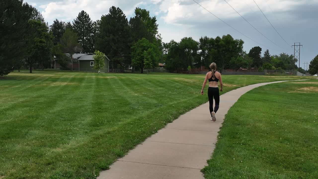 Walking along a pathway in a park this powerful and toned woman is demonstrating that women can exude confidence and power