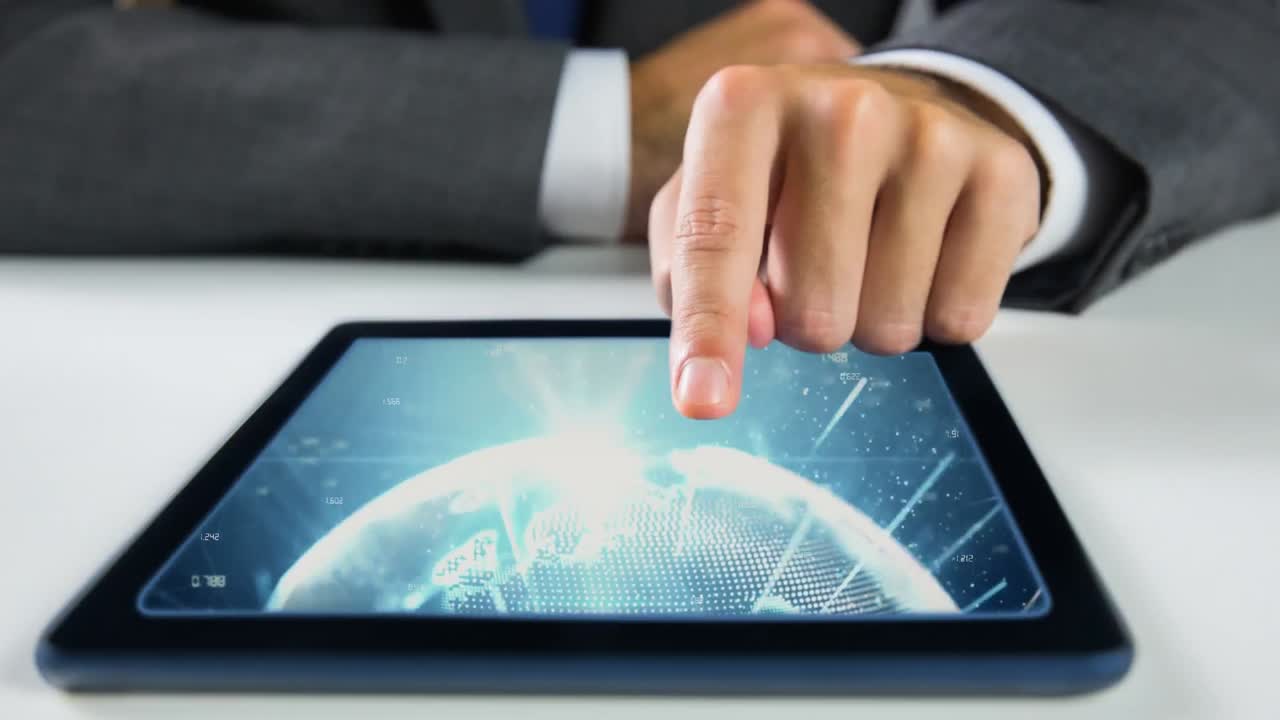 손이 만지는 태블릿은 세계 비디오를 보여줍니다.