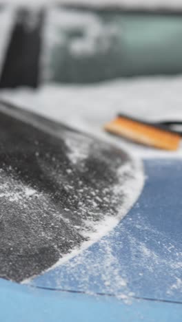 removing snow from a car in winter