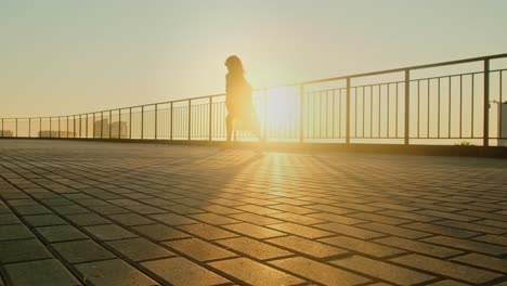 woman walking at sunrise on a balcony
