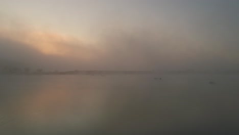 ghostly mist during sunrise above peaceful frydman lake, aerial